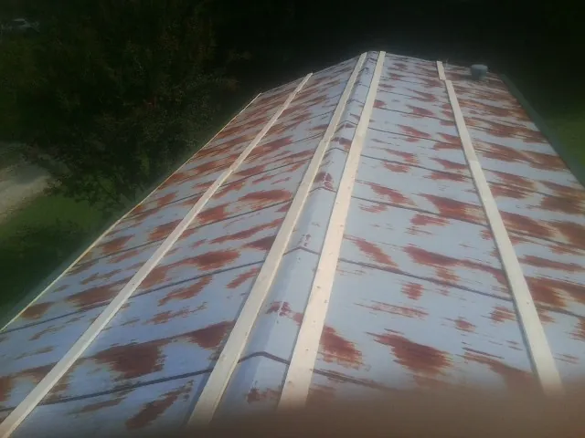 Rusted metal roof panels with new wood purlins before replacement — Storm Damage Roof Repair in Alsea by Roofing Brothers