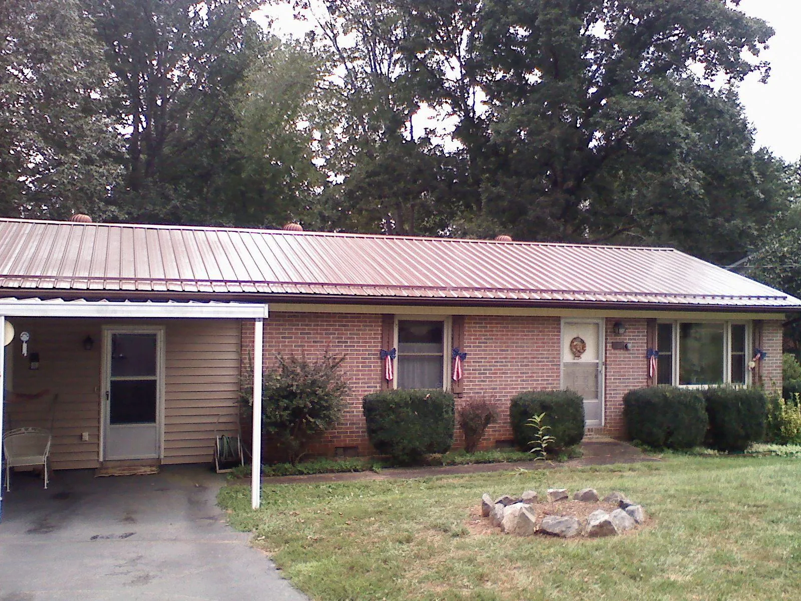Bronze metal roof and carport on a brick ranch home — Roof Repair work by our crew in Alsea